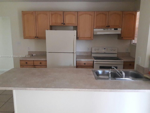 kitchen with tile patterned floors, white appliances, and sink