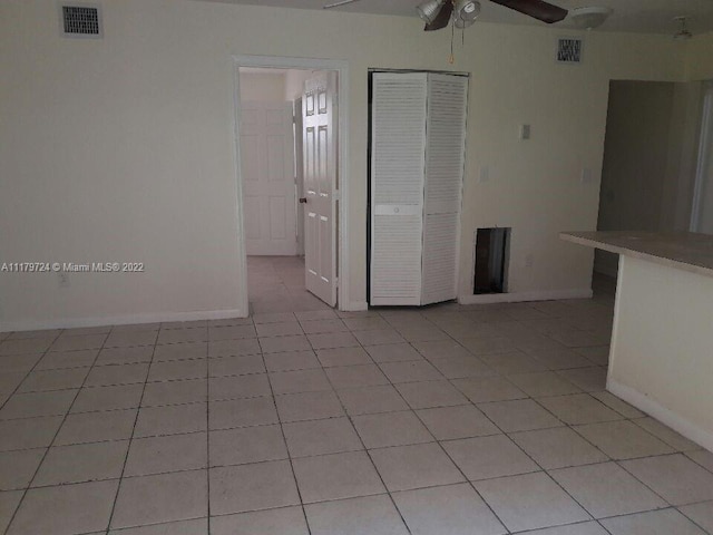 tiled empty room with ceiling fan