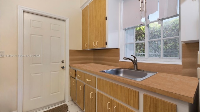 kitchen with sink, a healthy amount of sunlight, and light tile flooring