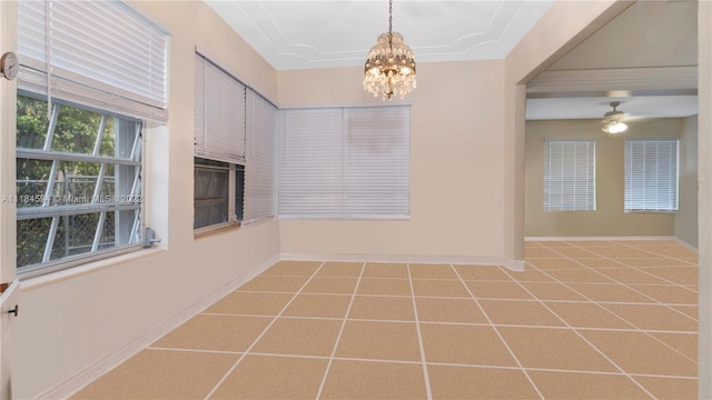 tiled spare room with ceiling fan with notable chandelier