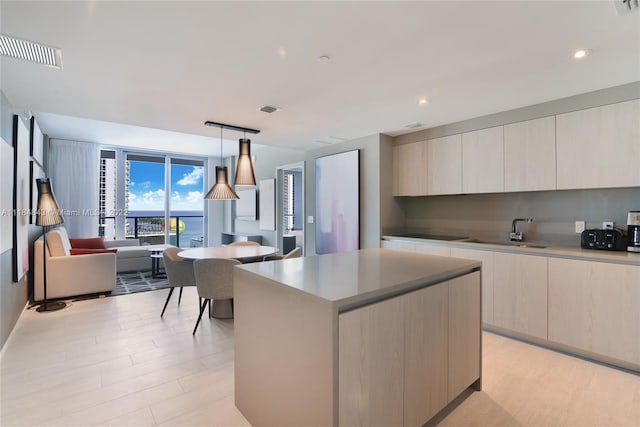 kitchen featuring light hardwood / wood-style flooring, sink, pendant lighting, and a center island