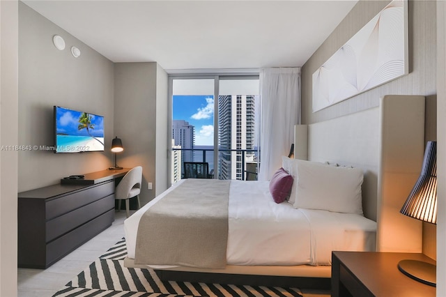 bedroom with access to exterior, floor to ceiling windows, and light hardwood / wood-style flooring