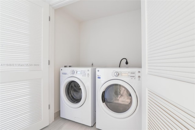 washroom featuring light hardwood / wood-style floors, hookup for an electric dryer, and separate washer and dryer