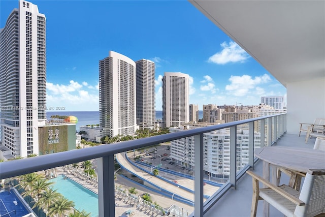 balcony with a community pool and a water view