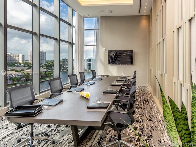 home office featuring plenty of natural light, expansive windows, and a high ceiling