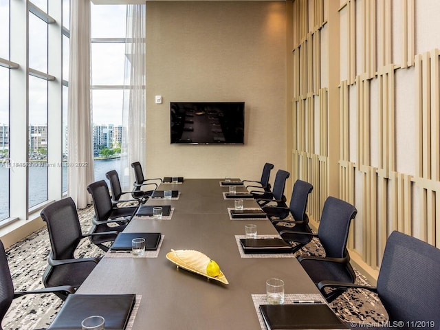 office area featuring a towering ceiling and a water view