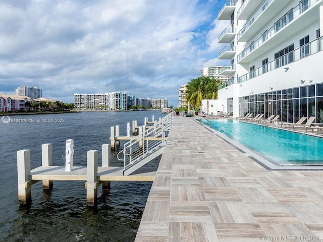 view of dock featuring a water view and a community pool