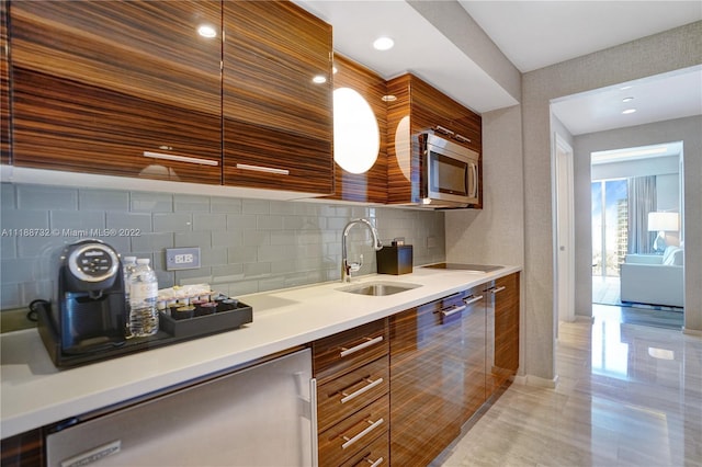 kitchen with backsplash, stainless steel appliances, light tile floors, and sink