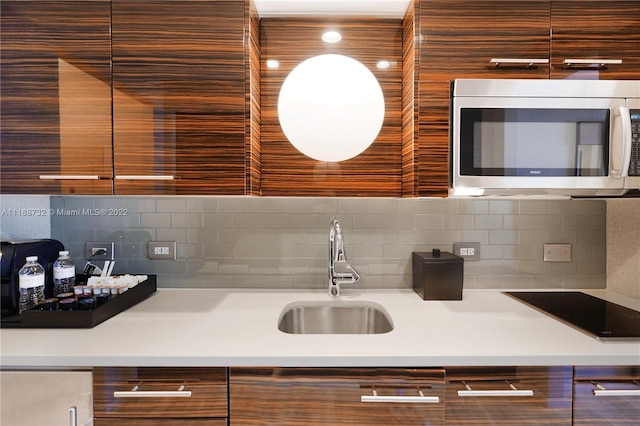 kitchen with backsplash, black electric cooktop, and sink