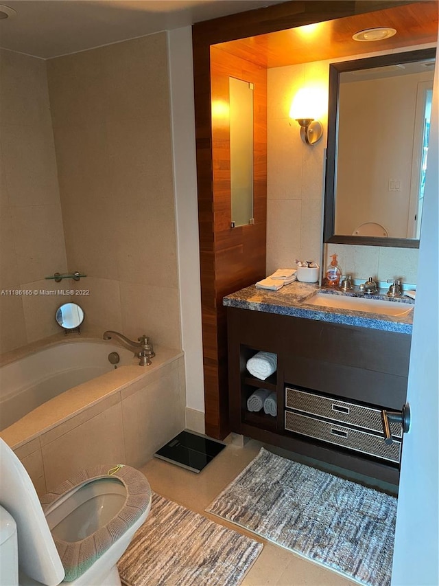 bathroom featuring toilet, tile floors, a relaxing tiled bath, and vanity