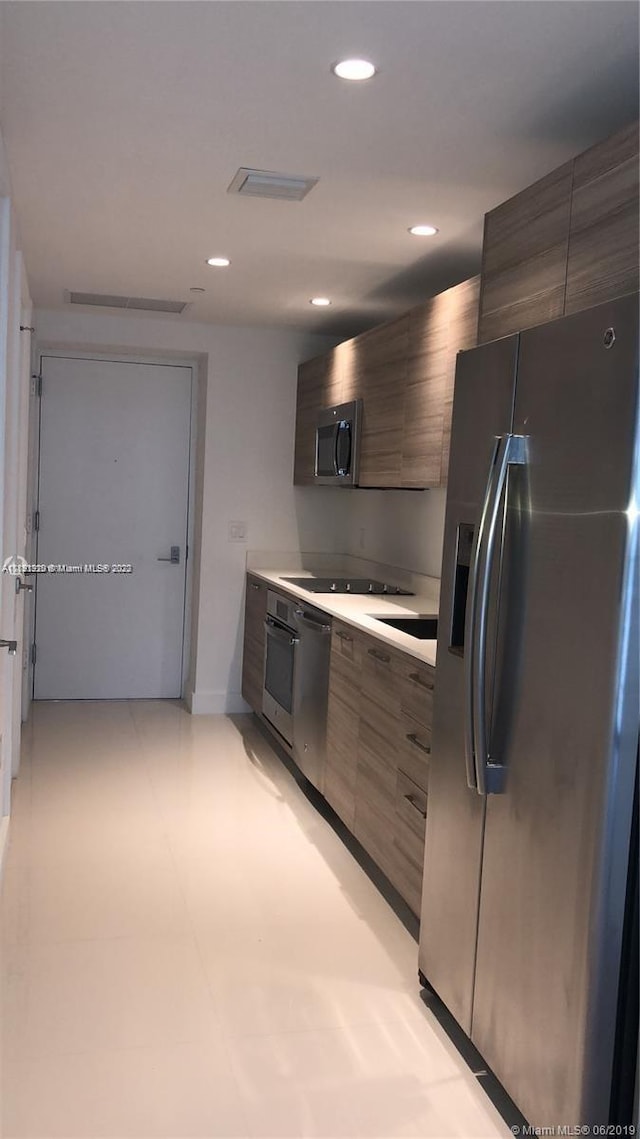 kitchen featuring appliances with stainless steel finishes and light tile floors