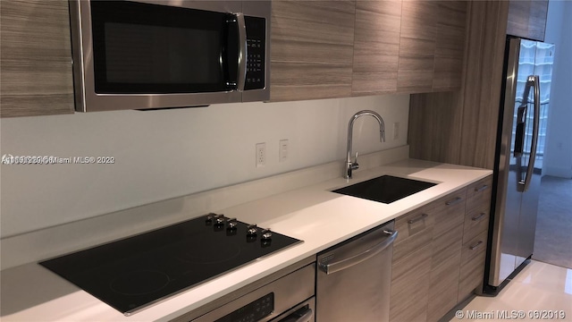 kitchen with stainless steel appliances, sink, and light tile floors