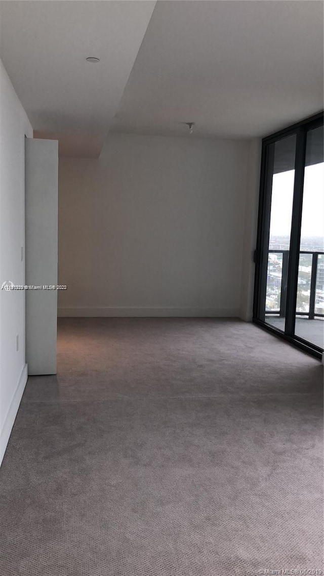 unfurnished room with dark colored carpet