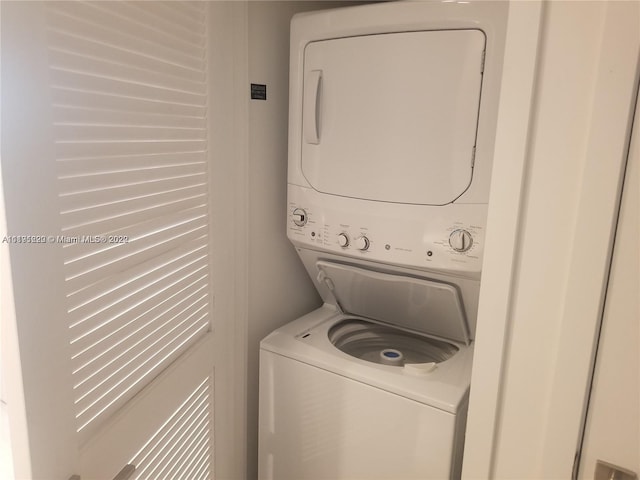 clothes washing area featuring stacked washer / dryer