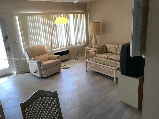 living area with light hardwood / wood-style floors and a healthy amount of sunlight