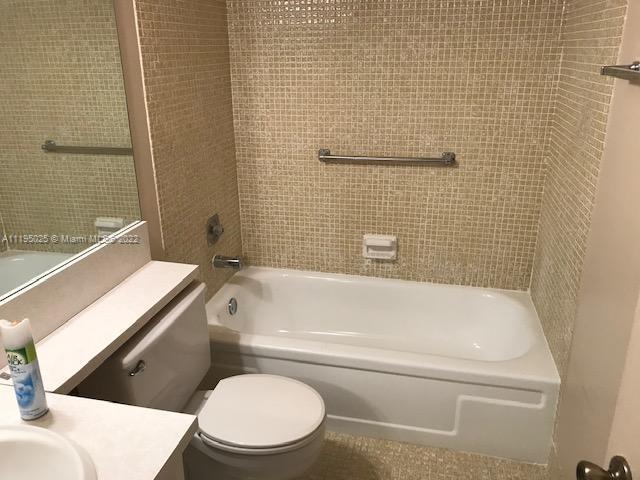 full bathroom with toilet, tiled shower / bath combo, and vanity