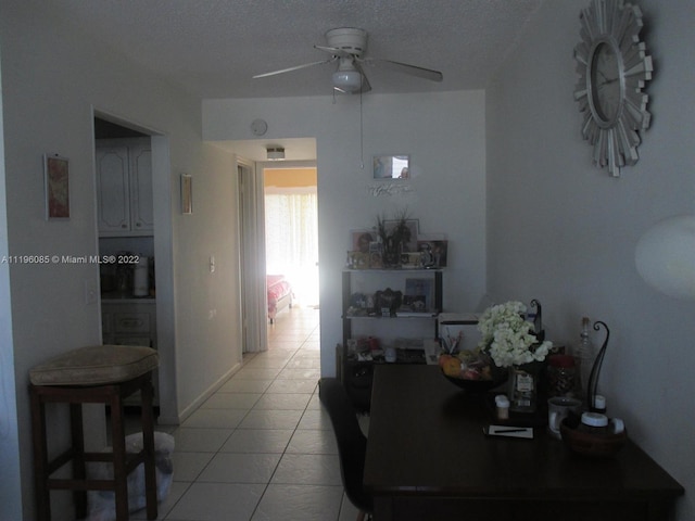 dining room featuring light tile floors, a textured ceiling, and ceiling fan