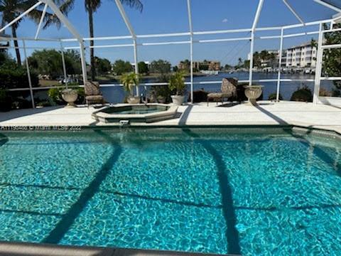 view of swimming pool featuring a patio, an in ground hot tub, and a lanai