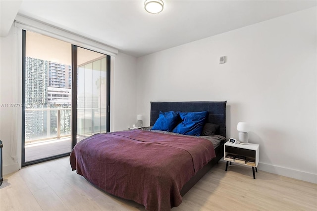 bedroom with access to outside and light wood-type flooring