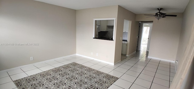 empty room with ceiling fan and light tile floors