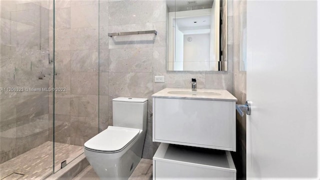 bathroom featuring vanity, walk in shower, toilet, and tile walls