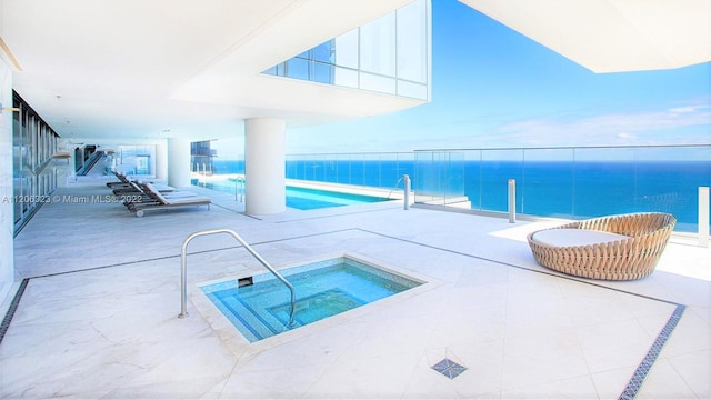 view of pool featuring a patio, a hot tub, and a water view