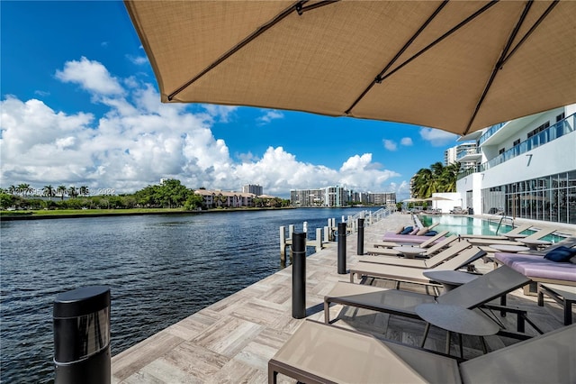 exterior space featuring a boat dock, a community pool, and a water view