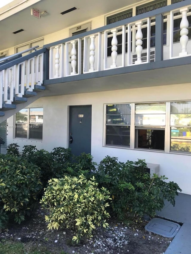 view of exterior entry with a balcony