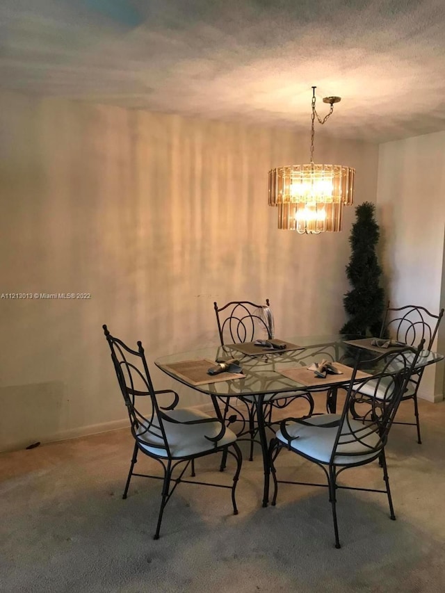 carpeted dining room featuring a chandelier