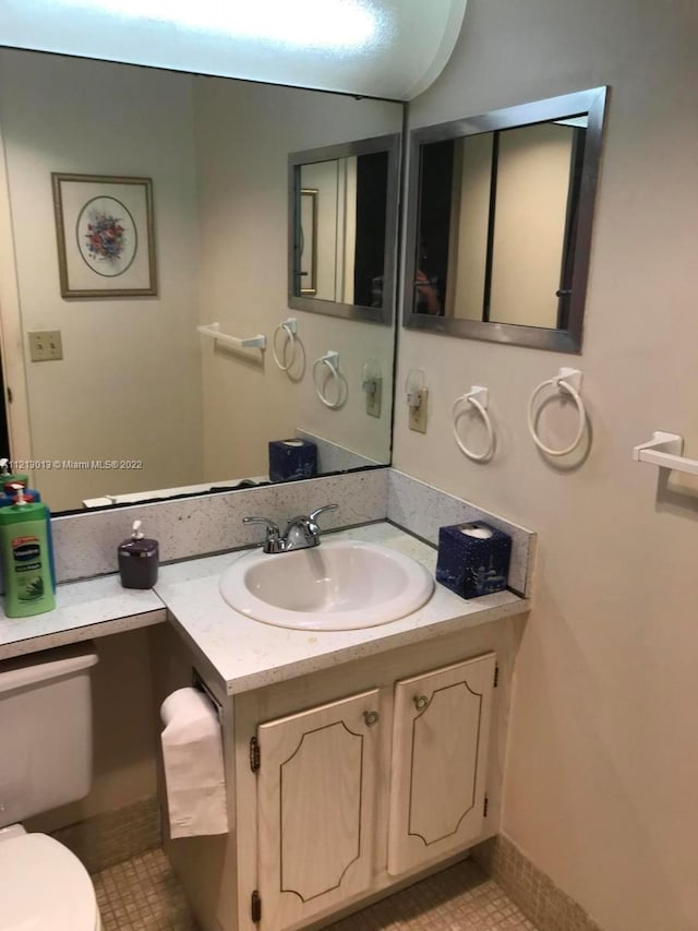 bathroom featuring toilet, tile floors, and vanity