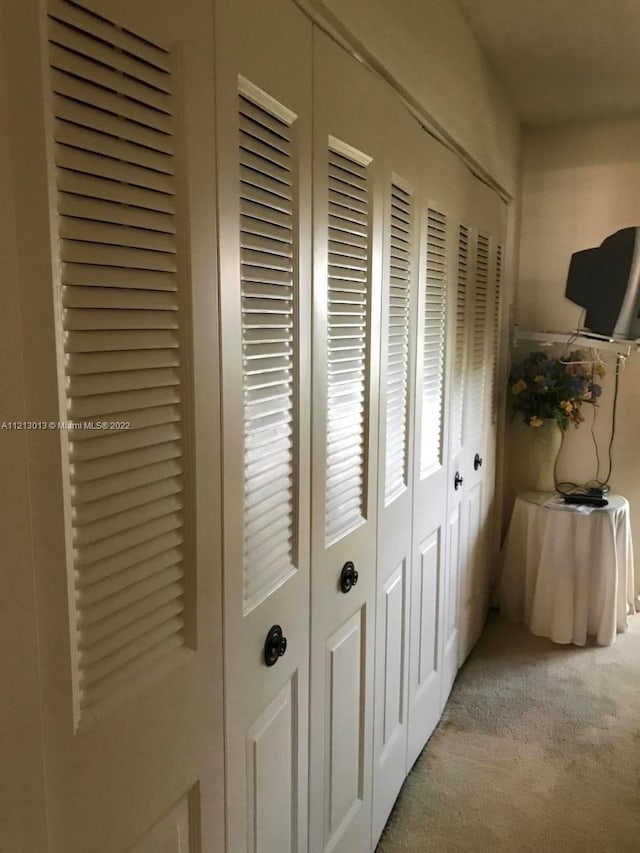 hallway featuring light colored carpet