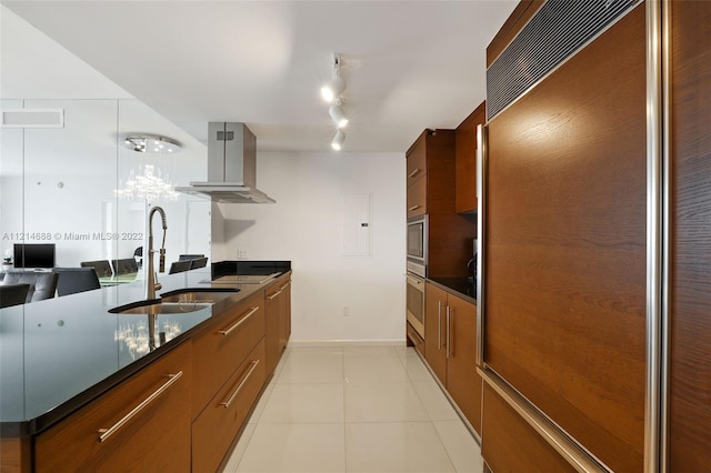 kitchen with island range hood, paneled built in fridge, stainless steel oven, track lighting, and sink