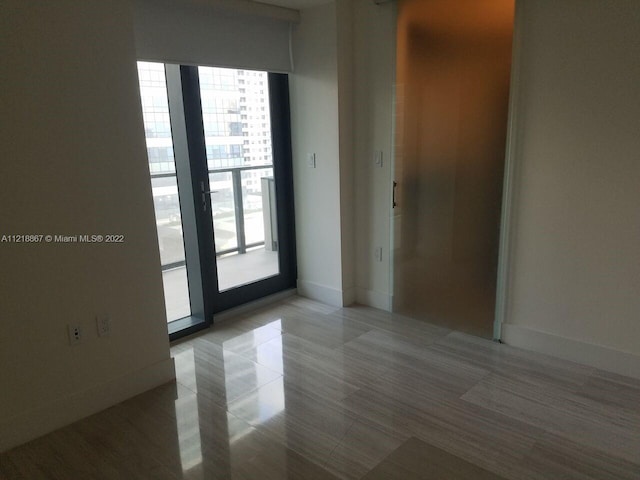 empty room featuring light tile flooring and a healthy amount of sunlight