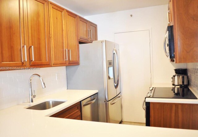 kitchen featuring tasteful backsplash, appliances with stainless steel finishes, and sink