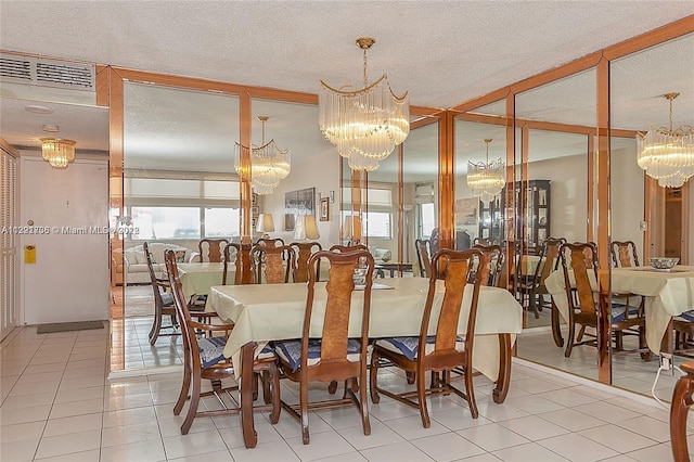 dining room featuring an inviting chandelier, a textured ceiling, and light tile floors