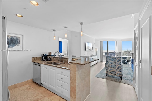 kitchen with dishwasher, sink, hanging light fixtures, dark stone counters, and white cabinets