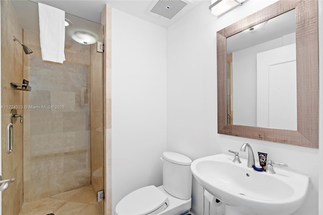 bathroom featuring toilet, an enclosed shower, and sink