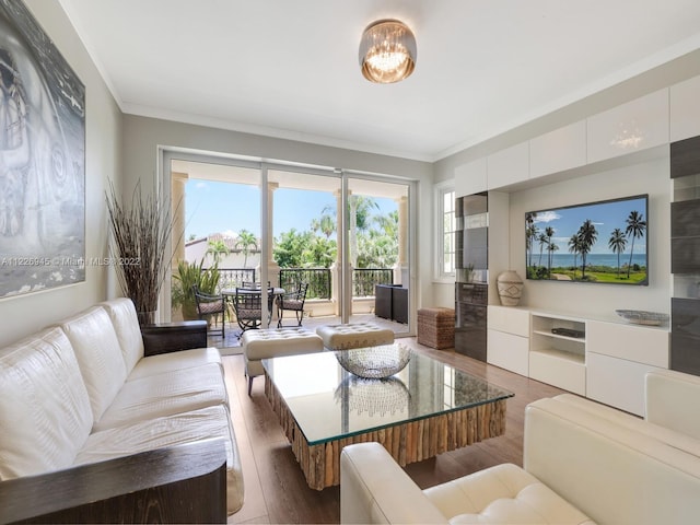 living room featuring hardwood / wood-style floors, ornamental molding, and a notable chandelier