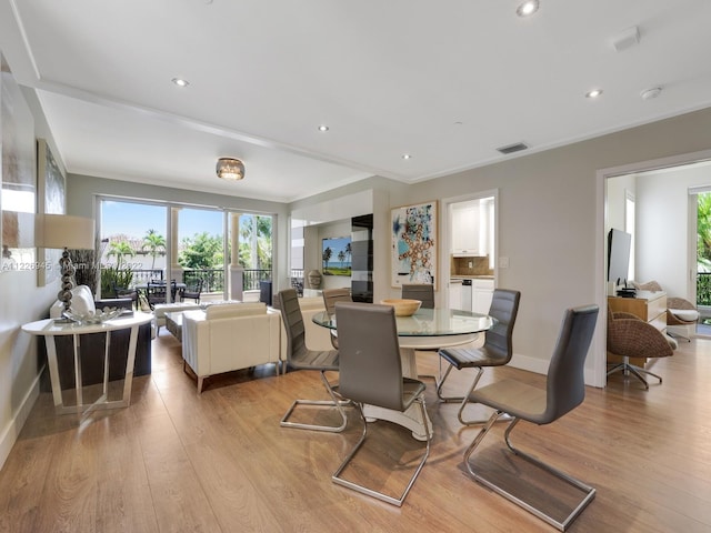 dining space featuring light hardwood / wood-style floors and ornamental molding