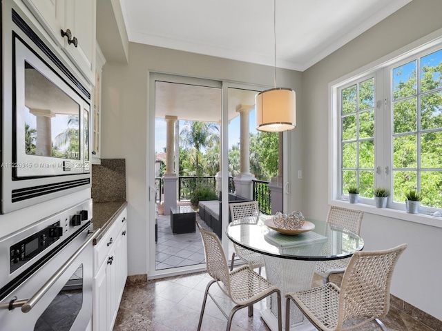 dining space with tile floors and crown molding