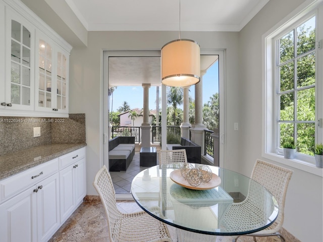 dining room with ornamental molding and light tile floors