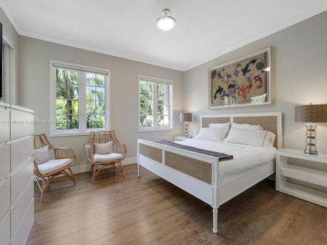 bedroom with crown molding and dark wood-type flooring