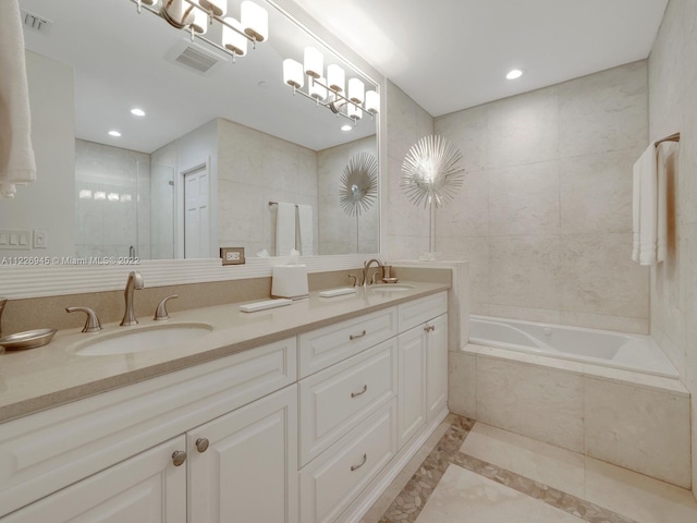 bathroom featuring tiled bath, tile flooring, and dual vanity