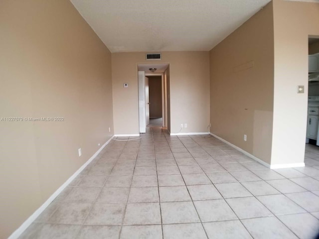 tiled spare room featuring a textured ceiling