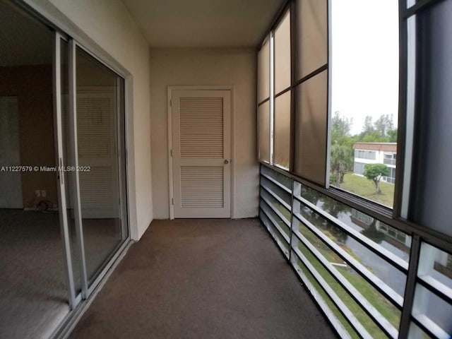 hallway featuring dark colored carpet