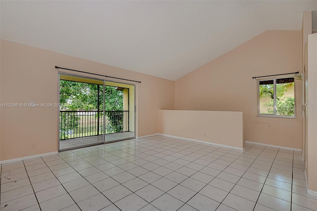 spare room with light tile flooring and high vaulted ceiling