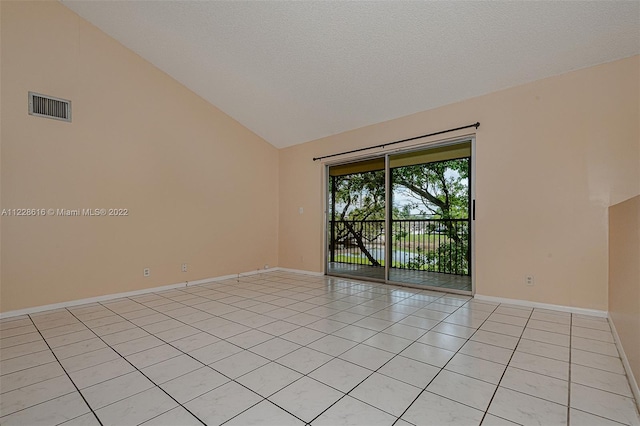 tiled empty room featuring high vaulted ceiling