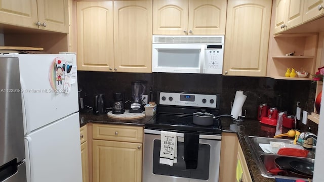 kitchen featuring backsplash, light brown cabinetry, sink, and white appliances