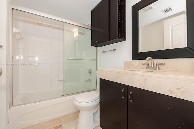 full bathroom featuring toilet, vanity, tile patterned floors, and shower / bath combination with glass door