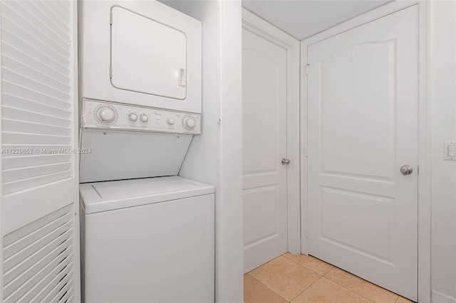 washroom featuring stacked washer / dryer and light tile patterned floors